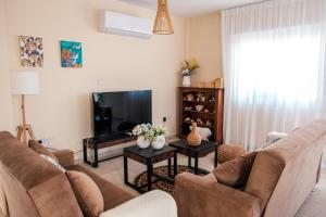 a living room with a couch and a tv at Mermaid Villa 16 in Ayia Napa