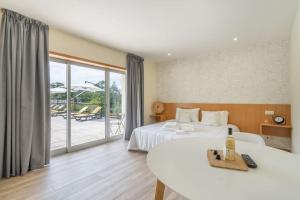 ein Hotelzimmer mit zwei Betten und einem Tisch in der Unterkunft Casa da Naia in Adaúfe + 36 Fotos