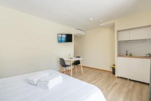 ein Schlafzimmer mit einem weißen Bett und einem Tisch in der Unterkunft Casa da Naia in Adaúfe