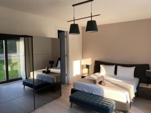 Un dormitorio con dos camas y una silla y un espejo. en Funkey Villas Istria, en Juršići 68 fotos más