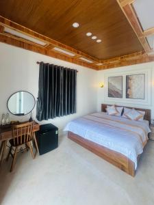 a bedroom with a bed and a desk and a chair at BÌNH MINH HOTEL - ĐẢO PHÚ QUÝ in Cu Lao Thu +19 photos