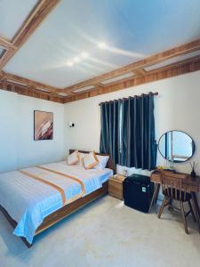 a bedroom with a bed and a desk and a window at BÌNH MINH HOTEL - ĐẢO PHÚ QUÝ in Cu Lao Thu