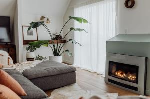 a living room with a fireplace and a couch at Sailor's Catch in Hokitika