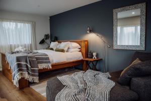 a bedroom with a bed and a mirror and a couch at Sailor's Catch in Hokitika