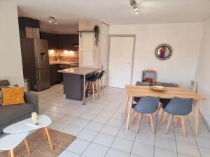 a kitchen and living room with a table and chairs at Un appartement calme et élégant in Avignon