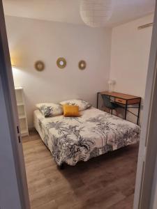 a bedroom with a bed with a table and a desk at Un appartement calme et élégant in Avignon +19 photos