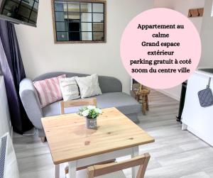 salon z kanapą i stołem w obiekcie Le Badebec, Appt dans maison typique avec jardin privé w mieście Chinon