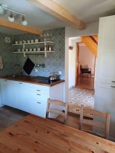 Una cocina con gabinetes blancos y una mesa y sillas. en Zielony Domek, en Żabnica