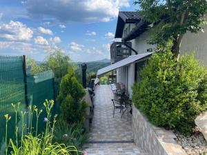 a stairway leading to a house with chairs and plants at Cabana Talea Residence Prahova in Plaiu