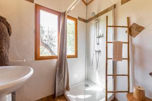 a bathroom with a shower and a sink and a shower at Cabane Dans les Arbres, Domaine de l Ogliastru in Olmeto