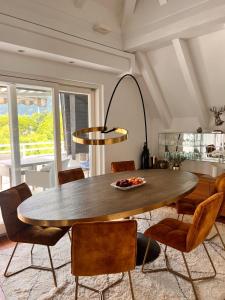 een eetkamer met een tafel en stoelen bij Penthousetraum im Herzen Merans in Merano +6 foto's