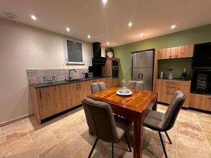 a large kitchen with a wooden table and chairs at Refuge des Sens à Sarlat Spa in Sarlat-la-Canéda +3 photos