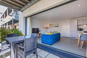 sala de estar con sofá azul en el balcón en 3 Challacombe - Luxury Apartment at Byron Woolacombe, only 4 minute walk to Woolacombe Beach!, en Woolacombe