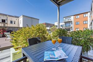 una mesa con dos vasos de zumo de naranja y un periódico en 3 Challacombe - Luxury Apartment at Byron Woolacombe, only 4 minute walk to Woolacombe Beach!, en Woolacombe