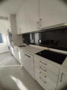 a kitchen with white cabinets and a sink at Casa lisboa in Livramento