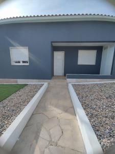 a blue building with a door and two windows at Casa lisboa in Livramento
