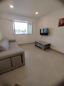a living room with a couch and a television at Casa lisboa in Livramento
