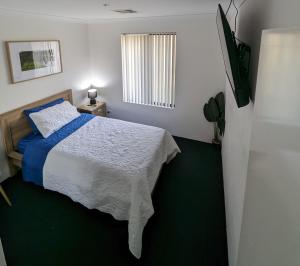 a small bedroom with a bed and a window at 4 Bedroom Wandina Home - 5 TVs & Close to Shopping Centre in Geraldton