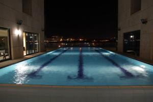 a large swimming pool in a building at night at Marina view 2bd Luxury Ap in Herzliya B