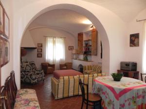 uma sala de estar com mesa e cadeiras e um quarto em Castello di Grotti em Corsano