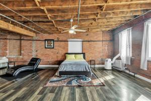 a bedroom with a bed in a brick wall at Stylish Chic Retreat at Lafayette Lofts apts in Detroit