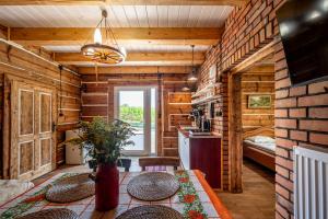 a room with wooden walls and a table and a kitchen at Orzechowa Ostoja noclegi Energylandia in Bachowice