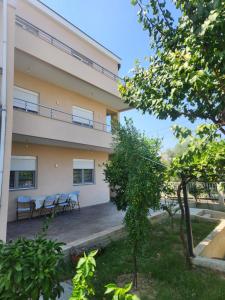 un edificio con tavoli e sedie di fronte di Duraku Apartment a Ulcinj