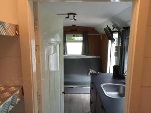 een keuken met een spoelbak en een aanrechtblad bij Verblijf Trijntje in Nieuwaal +9 foto's