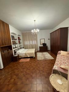 a bedroom with a bed and a couch in a room at Casa tra le vigne in Mombercelli