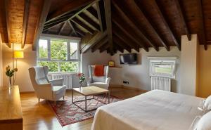 1 dormitorio con 1 cama grande y 2 sillas en Hotel Torre De Villademoros, en Luarca