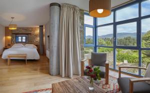 1 dormitorio con 1 cama y ventanas grandes en Hotel Torre De Villademoros, en Luarca