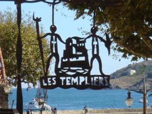 een teken dat leest les temperers hangend aan een boom bij Hôtel des Templiers in Collioure