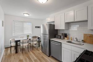 a kitchen with a refrigerator and a table with chairs at Cozy 2BR Near O Hare Free WiFi and Parking in Des Plaines