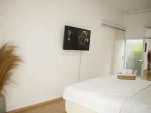 a white room with a tv on the wall at Villa Tjokro in Yogyakarta