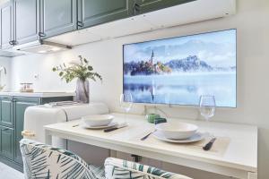 a kitchen with a table with two wine glasses and a painting on the wall at Easylife - Milano - Muratori 10 - Porta Romana in Milan