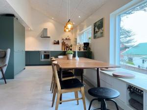 a kitchen with a wooden table and chairs at Stunning 3 Bedroom Family Friendly Retreat in Tvøroyri