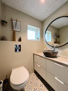 a bathroom with a toilet and a mirror at Stunning 3 Bedroom Family Friendly Retreat in Tvøroyri +14 photos
