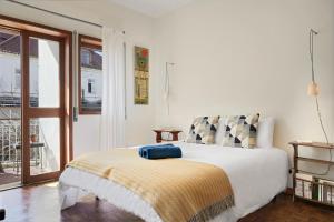 a bedroom with a bed with a yellow blanket on it at VIC Aveiro Arts House in Aveiro +59 photos