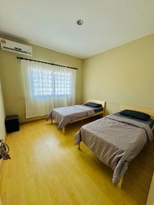 a room with two beds and a window at HmHome-Four in Rumah Ide
