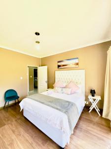 a bedroom with a large white bed with pink pillows at Townhouse on 6526 Boiketlo Street, Golfview in Mahikeng +8 photos