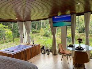 una camera con vasca, TV e letto di Loft Vidro View Rota do Vinho São Roque a São Roque