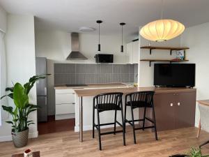 a kitchen with two chairs and a table with a tv at Bel appartement Ouest Parisien in Boulogne-Billancourt