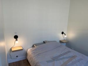 a small bedroom with a bed and two lamps at Bel appartement Ouest Parisien in Boulogne-Billancourt