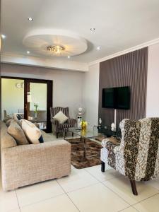 a living room with a couch and a table at Townhouse on 6526 Boiketlo Street, Golfview in Mahikeng