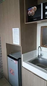 a small kitchen with a sink and a refrigerator at Urban Deca Tower OYO in Manila