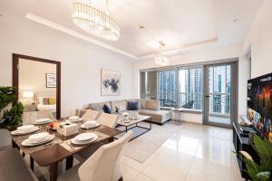 een woonkamer met een eettafel en een bank bij FIRST CLASS 3BR Burj Khalifa & Fountain View in Dubai