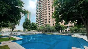 een groot blauw zwembad in een stad met hoge gebouwen bij FIRST CLASS 3BR Burj Khalifa & Fountain View in Dubai