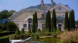 a large house with a pond in front of it at Pensjonat Well Clinic Medicine Estetic & Spa GDAŃSK in Gdańsk
