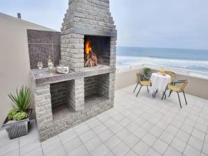 a patio with a fireplace and a table and chairs at First Group Desert Rose in Hentiesbaai