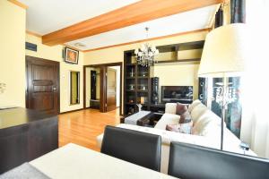 un soggiorno con divano bianco e lampadario pendente di Luxury Apartment a Braşov